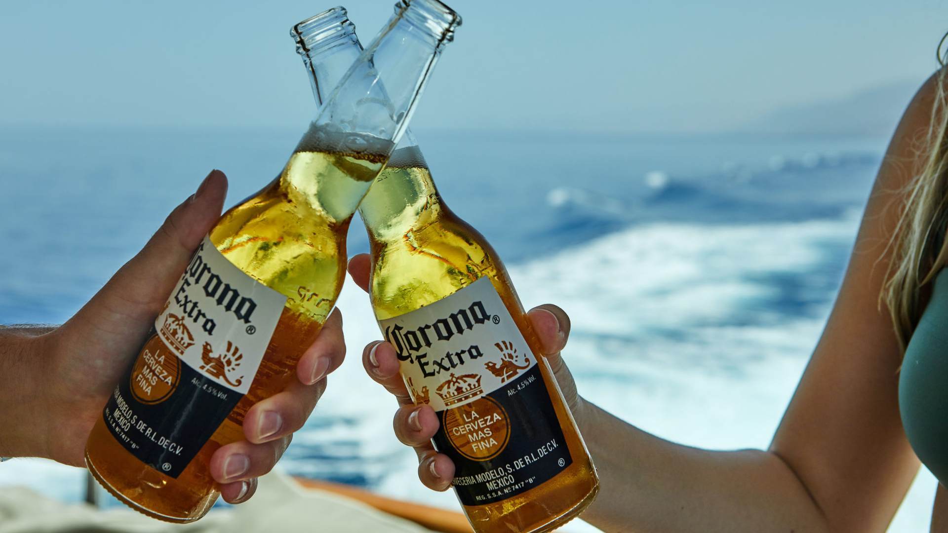 klinken met 2 flessen Corona op het strand